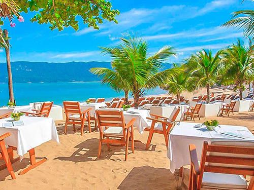 Mesas e coqueiros do DPNY Beach Hotel & SPA