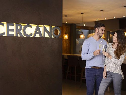 Casal na fachada do Hotel Cercano