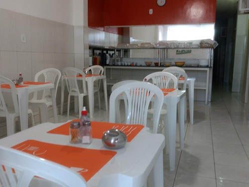 Mesas e cadeiras na Pousada Ilha Bela