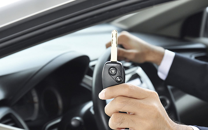 Pessoa segurando a chave de um carro Pessoa segurando a chave de um carro