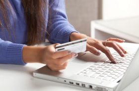 Usuária decidindo comprar passagem aérea ou de ônibus pela internet