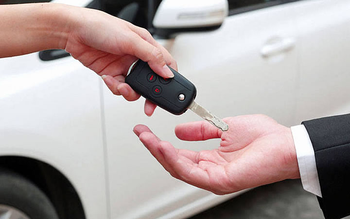 Alugar automóvel - Homem pegando a chave do carro
