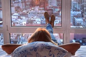 Mulher deitada uma cama de hotel observando Nova Iorque Mulher deitada uma cama de hotel observando Nova Iorque