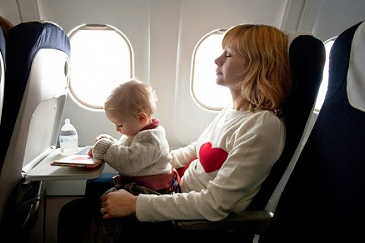 Bebê viajando de avião no colo da mãe Bebê viajando de avião no colo da mãe