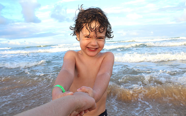 Criança sorrindo na Praia - Com pulseira de identificação Criança sorrindo na Praia - Com pulseira de identificação