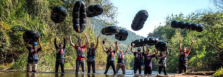 Pessoas em um rio jogando suas boias para cima Pessoas em um rio jogando suas boias para cima