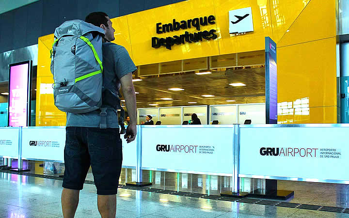 Homem em frente ao local de embarque no aeroporto Homem em frente ao local de embarque no aeroporto