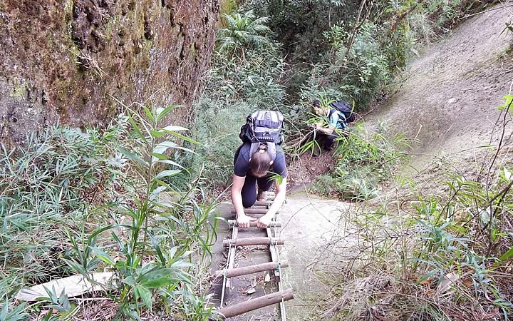 Mulher subindo escada na Trilha da Pedra Riscada Mulher subindo escada na Trilha da Pedra Riscada