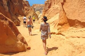 Pessoas passeando no labirinto de falésias na Praia das Fontes