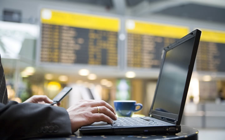 Homem com laptop no aerorporto Homem com laptop no aerorporto
