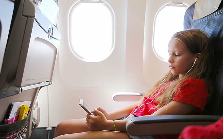 Menina ouvindo musica no avião Menina ouvindo musica no avião