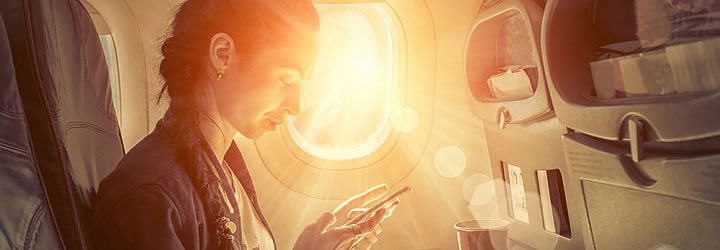 Mulher no avião com celular Mulher no avião com celular