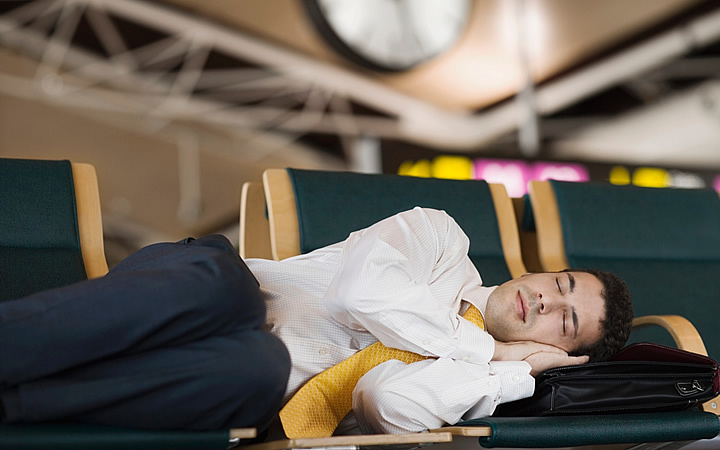 Homem dormindo nas cadeiras do aeroporto Homem dormindo nas cadeiras do aeroporto