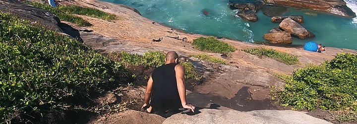 Homem tentando descer a trilha da praia do Secreto Homem tentando descer a trilha da praia do Secreto