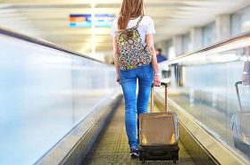 Menina puxando mala de viagem