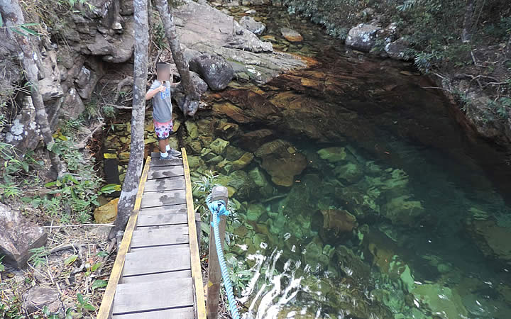 Menino próximo ao poço verde esmeralda na Cachoeira Loquinhas Menino próximo ao poço verde esmeralda na Cachoeira Loquinhas