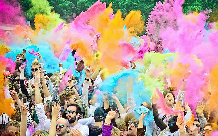 Pessoas jogando o pó colorido para cima no Holi Teen Pessoas jogando o pó colorido para cima no Holi Teen