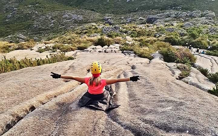 Mulher sentada no inicio da trilha para o Pico das Agulhas Negras Mulher sentada no inicio da trilha para o Pico das Agulhas Negras