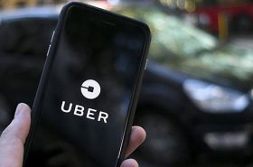 Pessoa segurando telefone com app do Uber