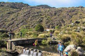 Pessoas atravessando o lago do Abrigo Rebouças - Pedra do Altar - Itatiaia