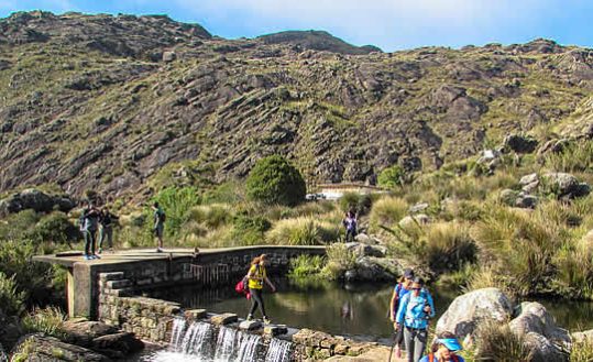 Pessoas atravessando o lago do Abrigo Rebouças - Pedra do Altar - Itatiaia