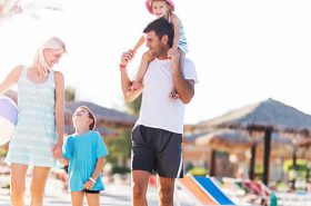 Família andando na praia - Viajar nas férias