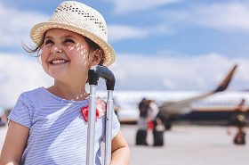Menina segurando a mala de viagem