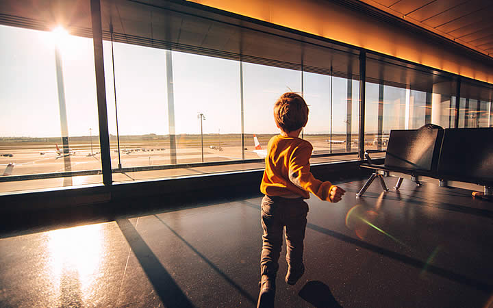 Menino correndo em pátio - Aeroporto Menino correndo em pátio - Aeroporto