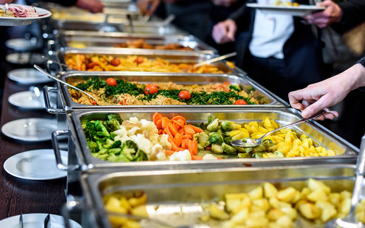 Pessoas se servindo em restaurante Pessoas se servindo em restaurante