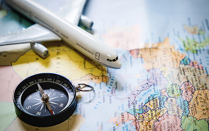 Avião e bússola em cima de uma mapa Avião e bússola em cima de uma mapa
