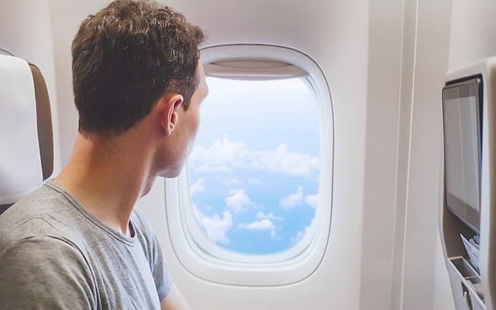 Homem olhando de janela de avião Homem olhando de janela de avião