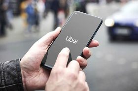 Pessoa segurando celular no Aplicativo Uber