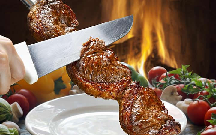 Churrasqueiro cortando carne Churrasqueiro cortando carne