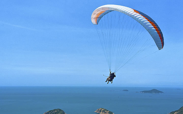 Pessoa voando de parapente Pessoa voando de parapente
