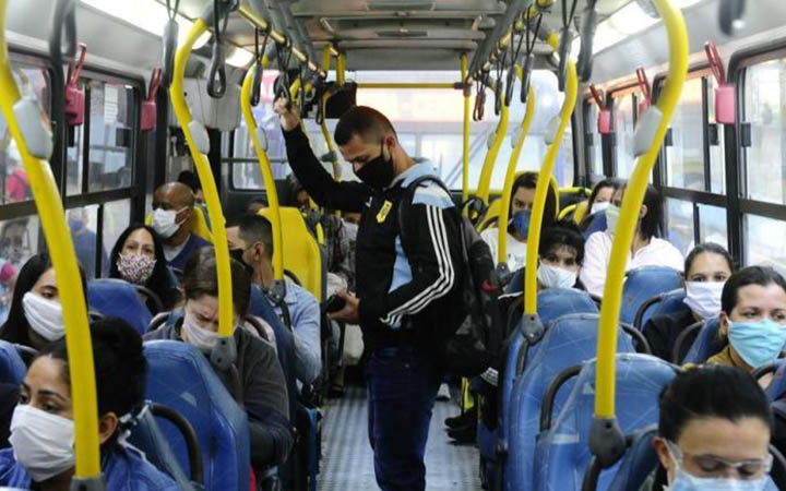 Pessoas com máscara dentro do ônibus Pessoas com máscara dentro do ônibus