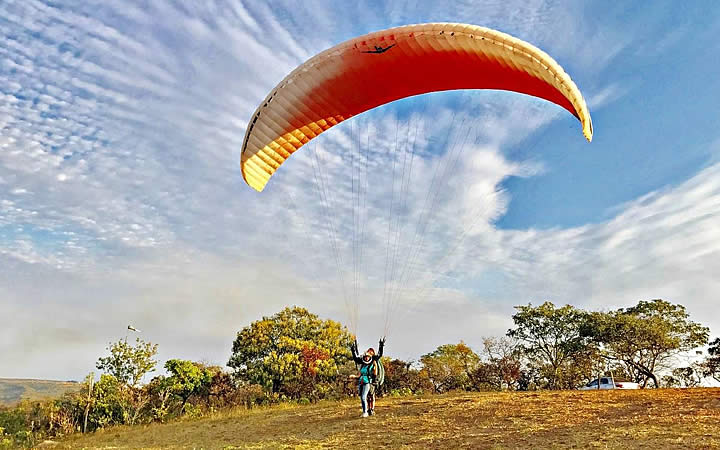 Pessoas em um campo com parapente acionado Pessoas em um campo com parapente acionado