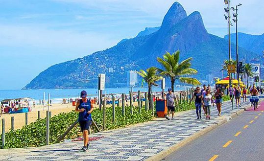 Leblon - Pessoa correndo na calçada próximo a orla da praia