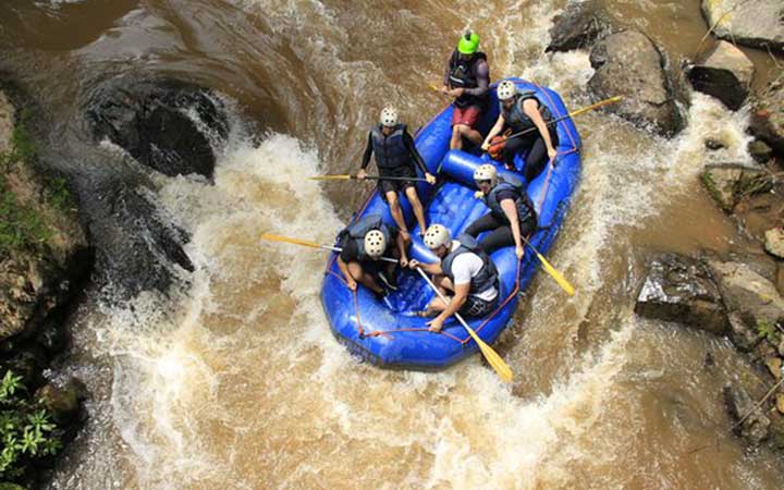 Radix Aventura | Pessoas em um bote azul no rio Extrema