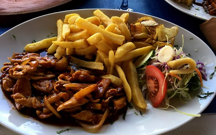 Prato com tomate, batata frita e carne