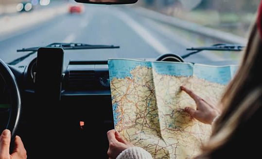 Pessoas dentro do carro com mapa de viagem