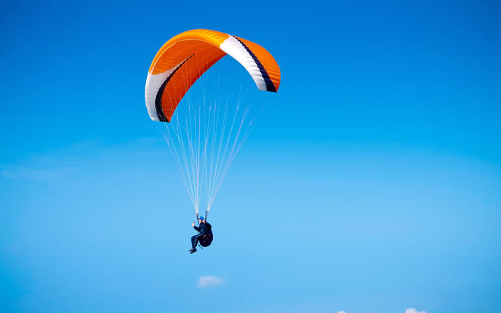 Paraquedas Laranja em céu azul